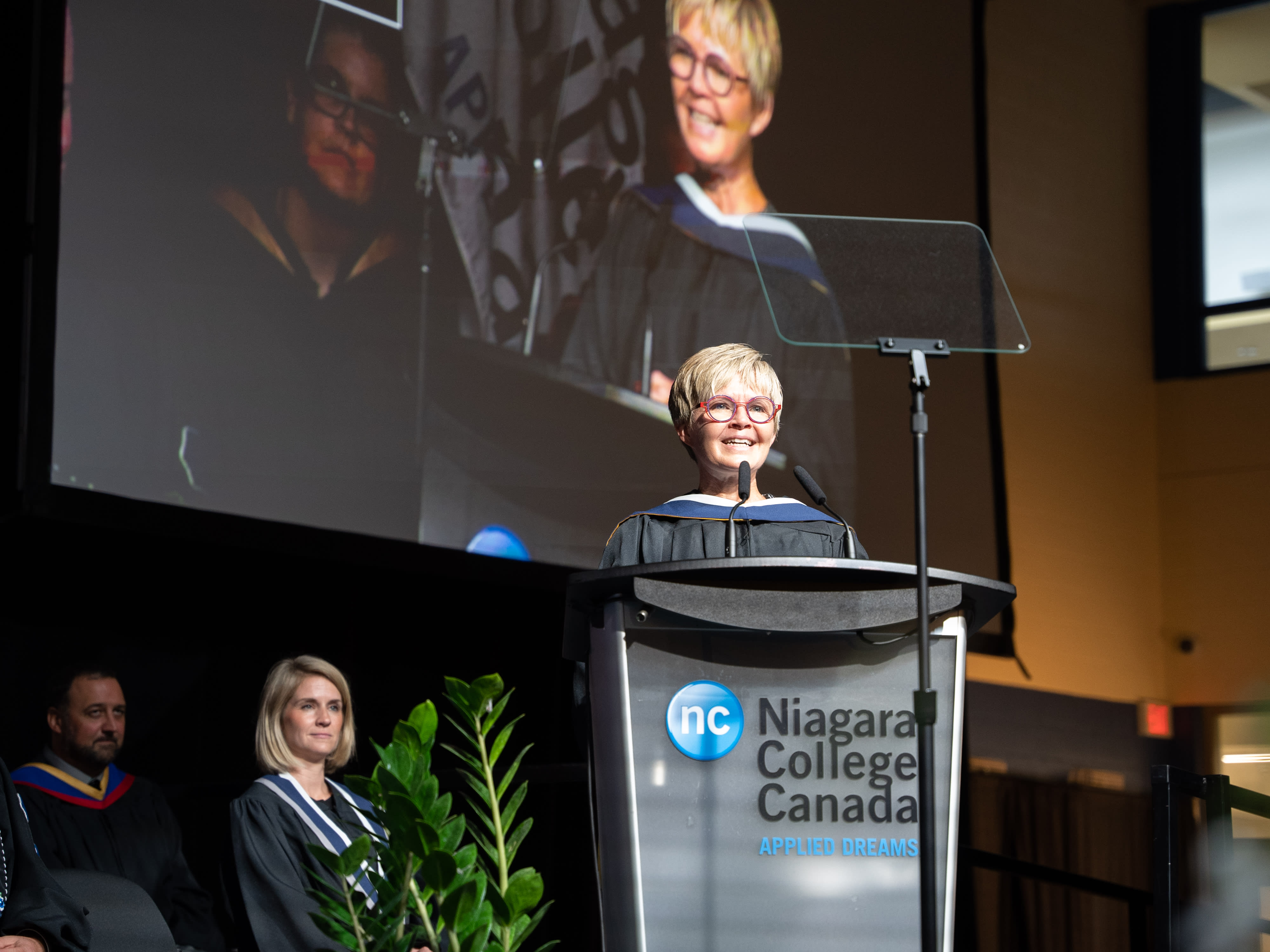 Niagara Health President and CEO Lynn Guerriero stands at a podium on stage. 