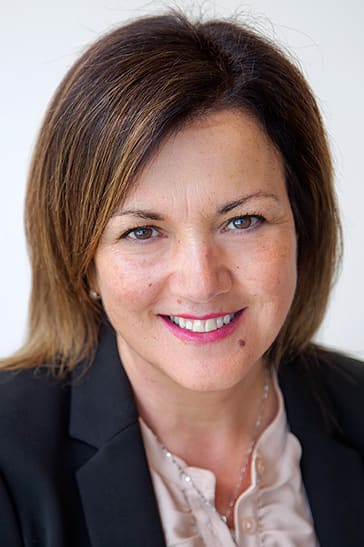 A woman with shoulder-length brown hair smiles for the camera.