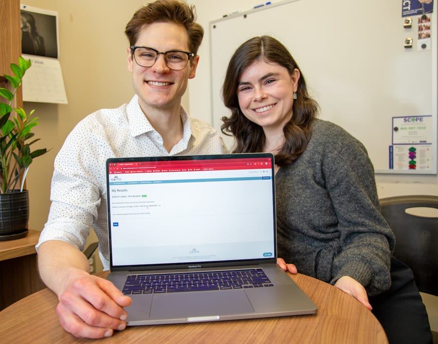 MacNRC student Grant Sweeny and his wife Emily DiMatteo with the CARMS website open on their laptop