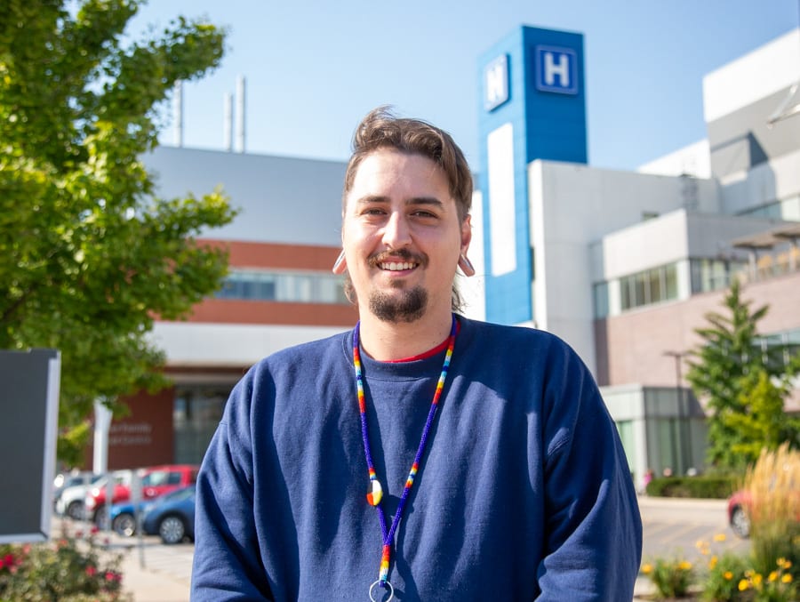 Isaiah Beardy stands outside the Marotta Family Hospital on a sunny day