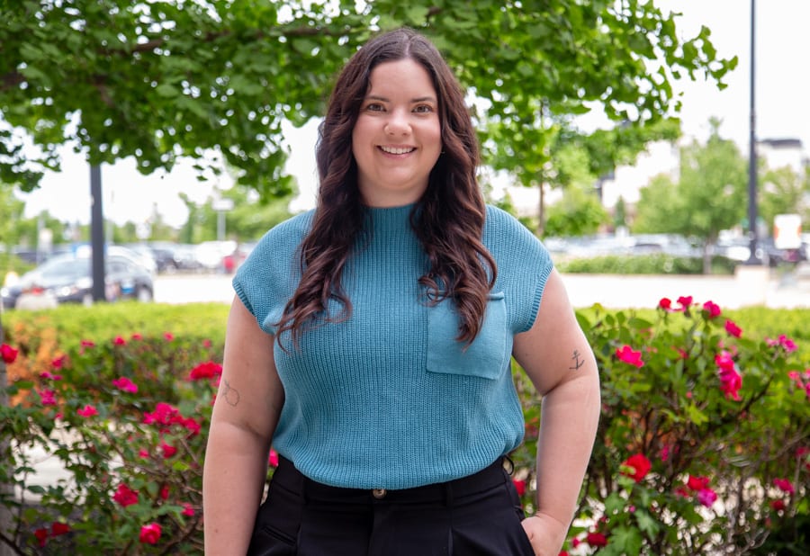 Kiersten Vaananen, Registered Nurse, Niagara Health, stands outside against a backdrop of roses.