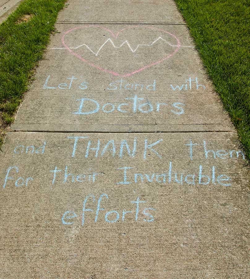 Messages of support for healthcare workers written on a sidewalk