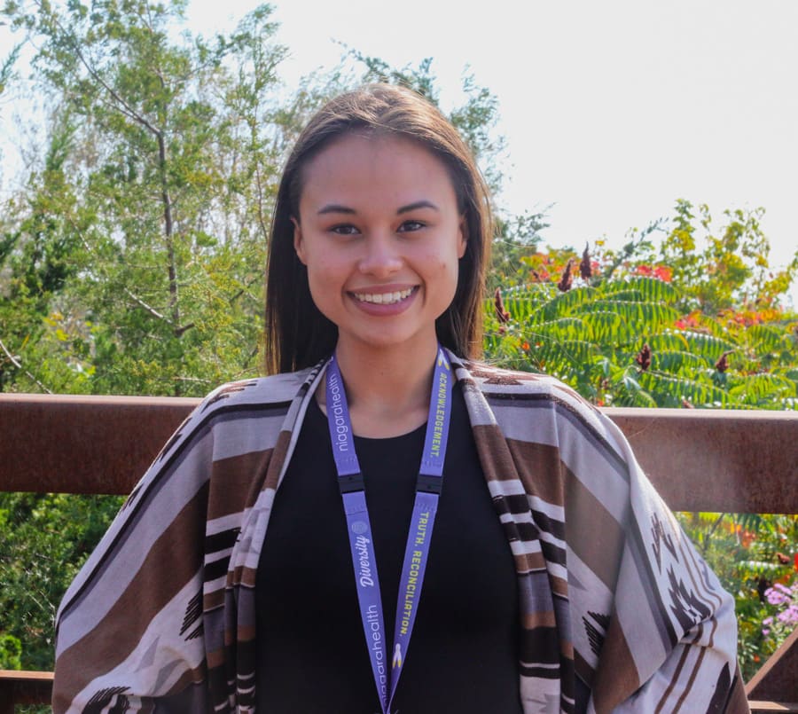 Shyan Jenkins stands outside the hospital, smiling.