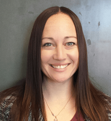 A portrait of a woman with long brown hair smiling for the camera