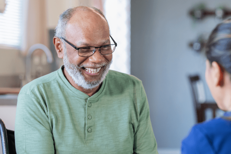 Smiling senior man in conversation with a healthcare team member