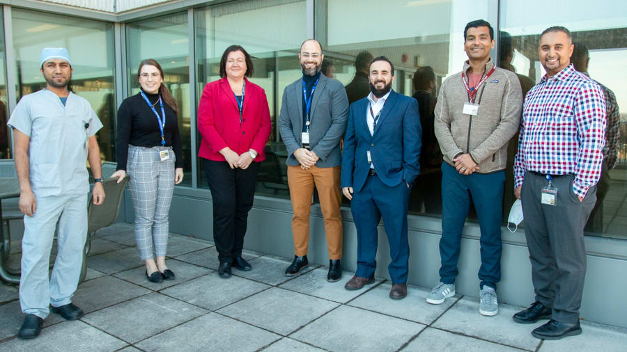 Clinical Utilization Committee. A group of people stand outside and pose for a photo. They are doctors and hospital administrative staff