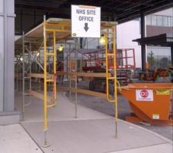 scaffolding in front of the new hospital building with sign that reads NHS site office